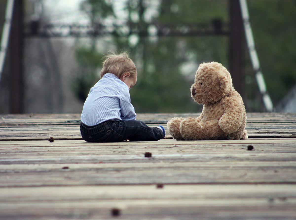 Small kid taking to his toy representing creating relationships.